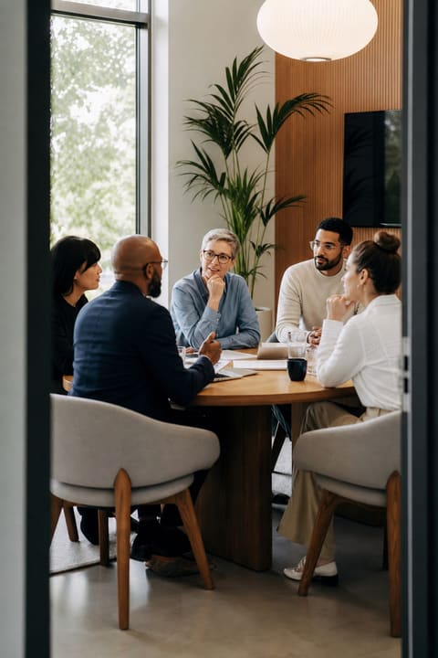 A GTC attorney reviewing a board charter and risk register with a startup's directors in a bright modern office